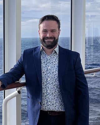 Valentin smiling on a ship deck, sea behind
